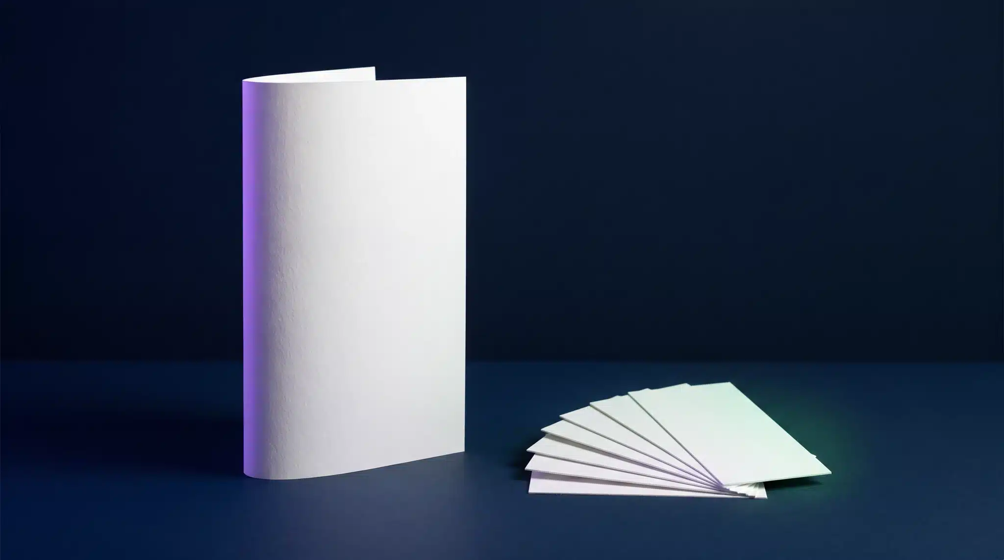 One tall single sheet representing a single page website beside a fan of separate cards representing a multi-page website, deep navy with violet and green accents.